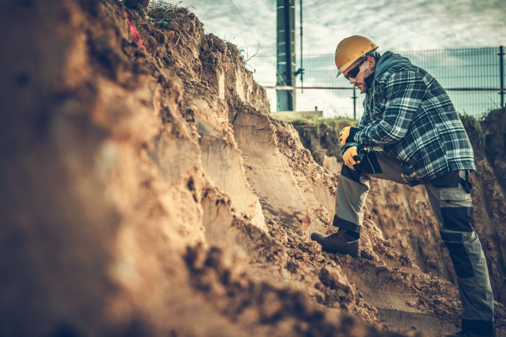 A construction worker analyzes the digging of soil before he continues with his big project