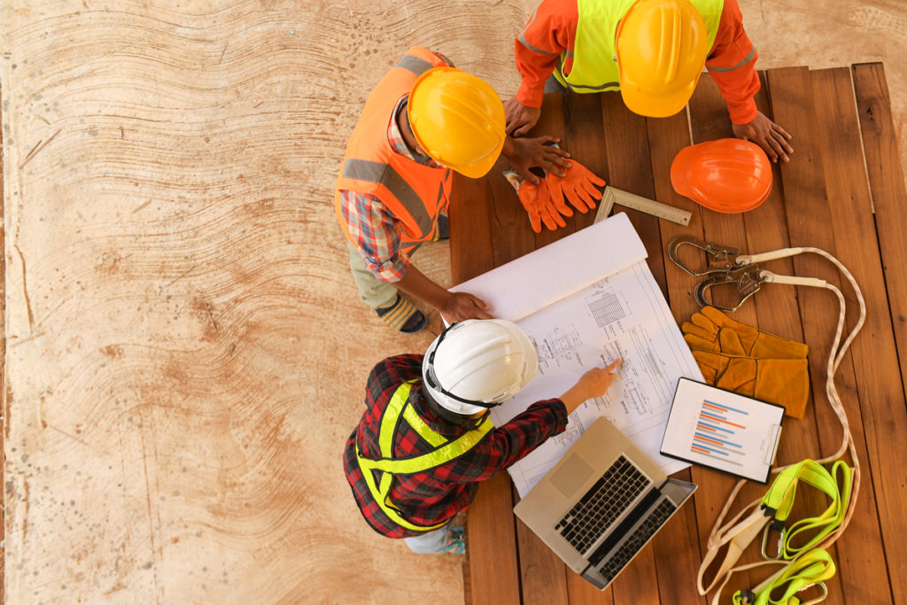 Aerial view of construction workers going over building plans in Carlsbad.